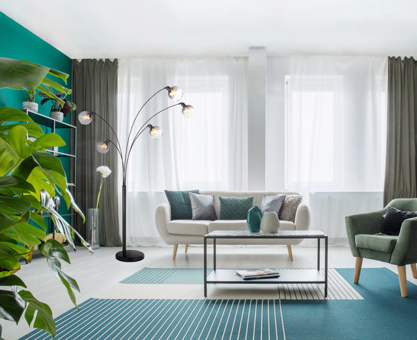 Stehleuchte Globo Seymour 208 cm neben dem Sofa im Wohnzimmer, fünf Rauchglasschirme über der Sitzecke [AI]
