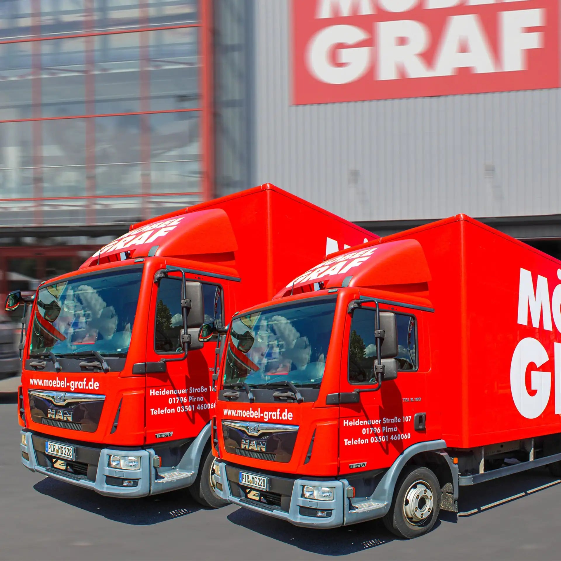 Gartenmöbel-Lieferung Dresden – Zwei rote MAN-Lieferwagen Möbel Graf mit Adresse Heidenauer Straße Pirna