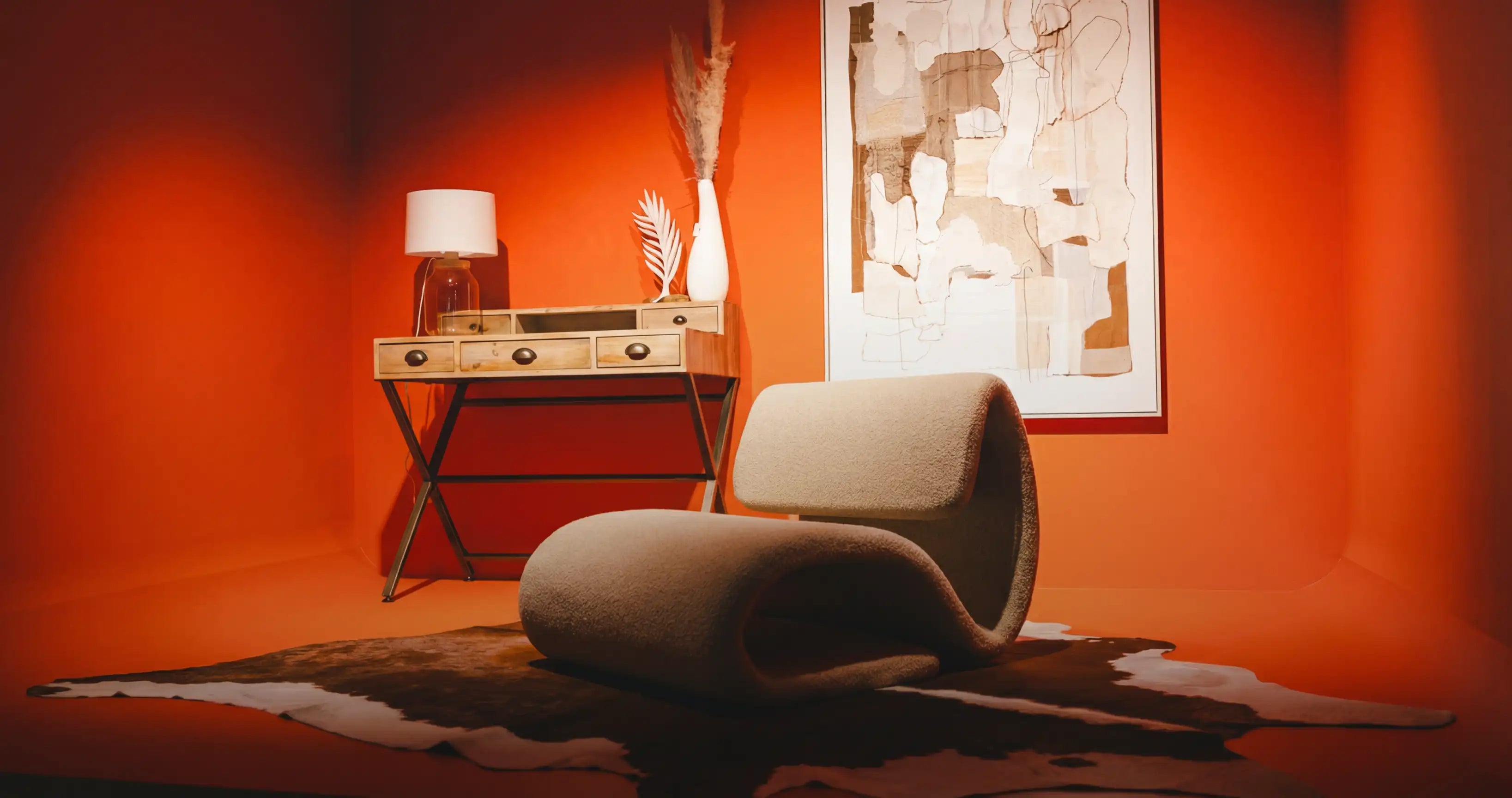 Polstermöbel Dresden – Bouclé-Lounge-Sessel in Rollenform vor orangeroter Wand mit Konsolentisch, Möbel Graf Pirna