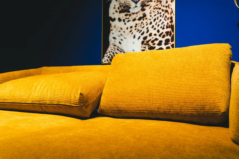 Polstermöbel Dresden – Senfgelbes Cord-Sofa vor Leoparden-Wandbild auf kobaltblauem Hintergrund, Möbel Graf Pirna