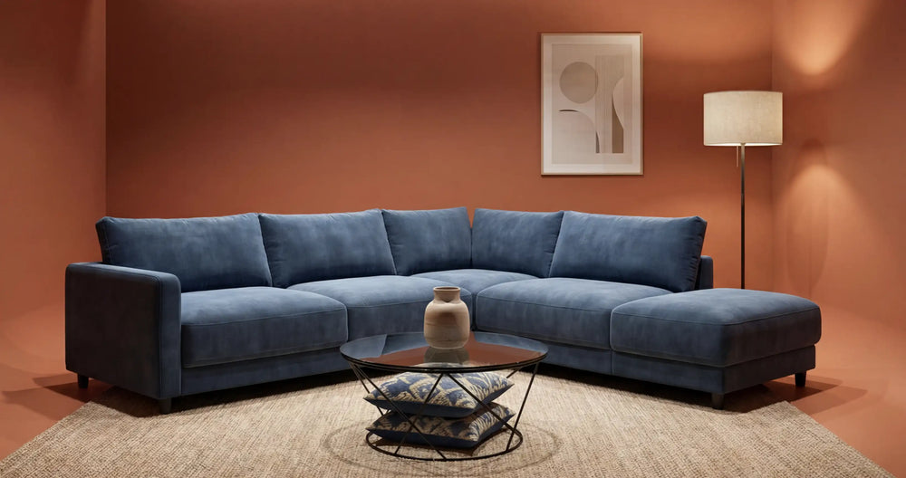 Polstermöbel Dresden – Stahlblaues Ecksofa vor altrosa Wand mit Glascouchtisch, Polstermöbel-Ausstellung Möbel Graf Pirna