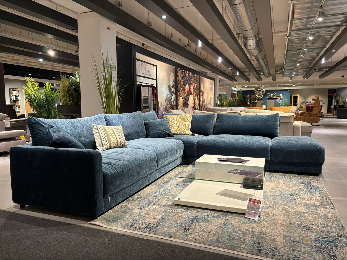 Polstermöbel Dresden – XXL Blaues Samt-Ecksofa mit Marmor-Couchtisch vor Wandbild in der Ausstellung Möbel Graf
