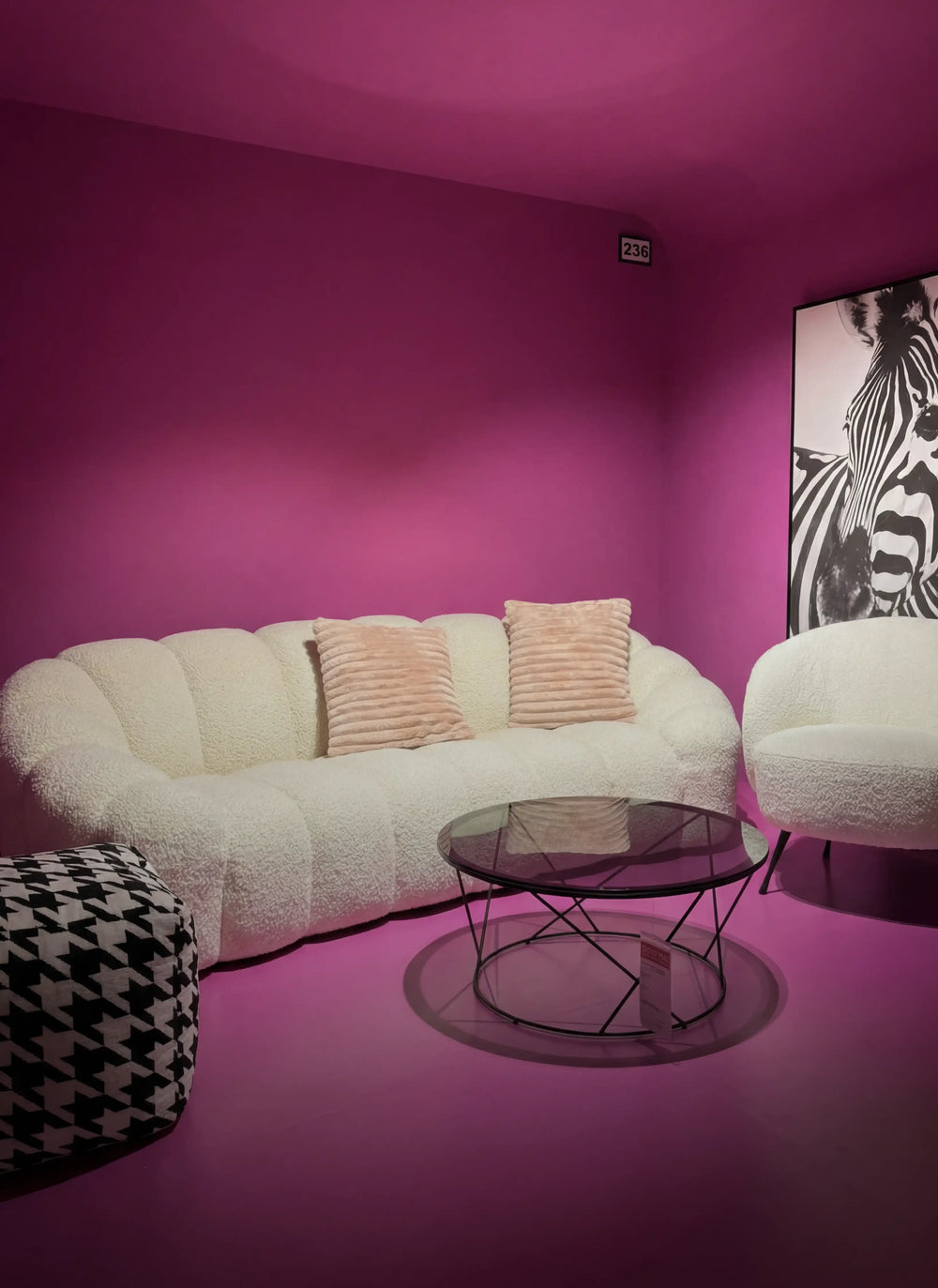 Polstermöbel Dresden – Weißer Bouclé-Sessel auf Kuhfell-Teppich vor orangeroter Wand, Möbel Graf Pirna