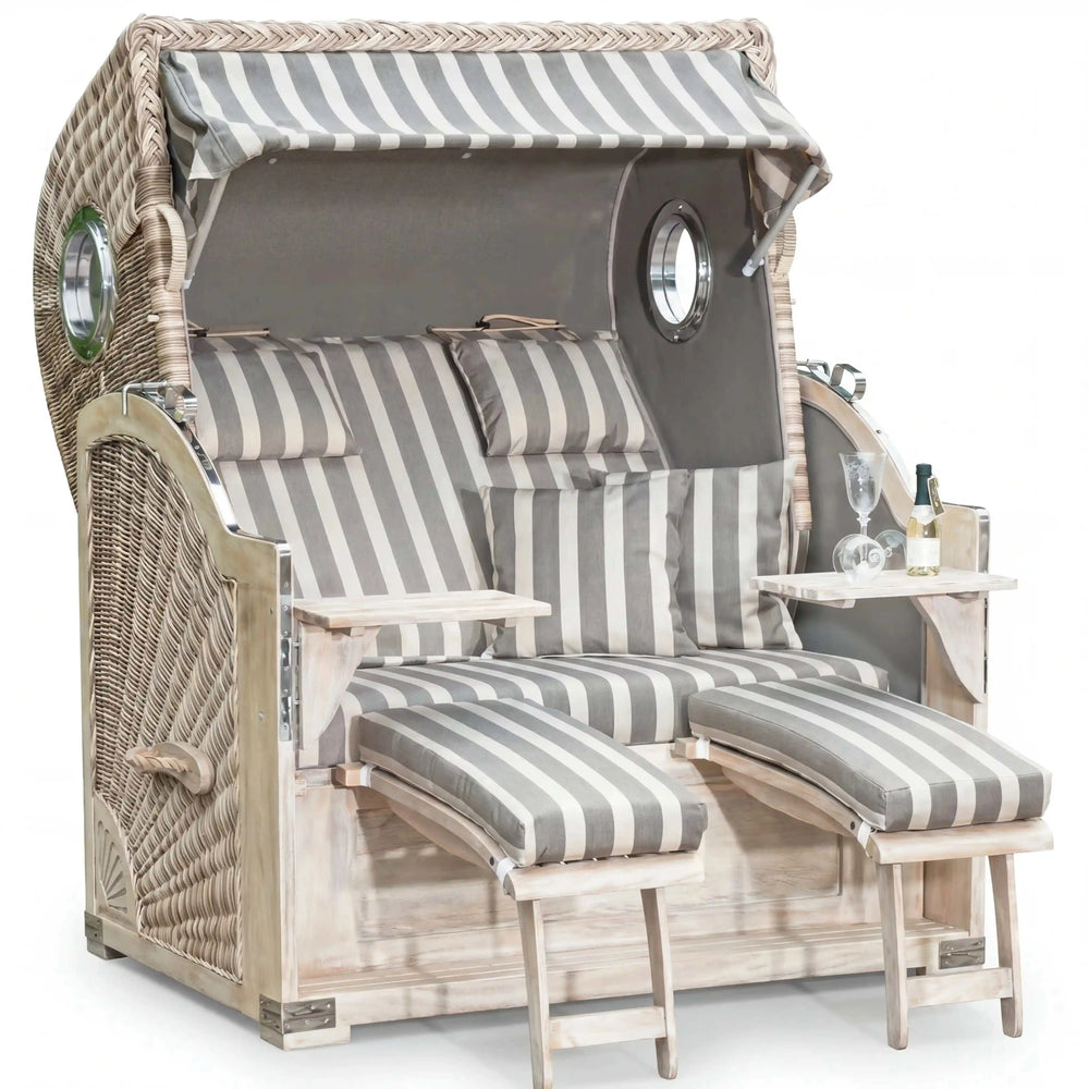 Gartenstrandkorb Comfort 500 Plus aus Mahagoni mit antik-weißem Kunststoff-Rundgeflecht und seitlichen Bullaugen, 3/4-Liegemodell im XL-Format mit taupefarbenem Stoff.